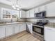 Modern kitchen features white cabinets, granite countertops, and stainless steel appliances at 200 Indian Branch Dr, Morrisville, NC 27560