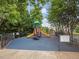 Community playground featuring a colorful slide and play structure surrounded by lush trees and a secure fence at 200 Indian Branch Dr, Morrisville, NC 27560