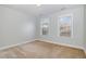 Carpeted bedroom with two windows and neutral paint at 205 Quarryrock Rd, Holly Springs, NC 27540