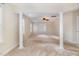Spacious room featuring decorative columns, a ceiling fan, and lots of natural light from multiple windows at 205 Quarryrock Rd, Holly Springs, NC 27540