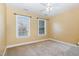 Bedroom with two windows for natural light, carpeted floors, and a ceiling fan at 205 Quarryrock Rd, Holly Springs, NC 27540