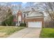 Charming brick two-story home with a well-manicured lawn and attached two-car garage at 205 Quarryrock Rd, Holly Springs, NC 27540