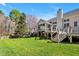 Backyard view featuring a deck, screened porch and lush green lawn and trees at 207 Alumni Ave, Durham, NC 27713