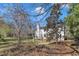 Back exterior of the home, deck and partially wooded lot with bare trees at 207 Lewey Brook Dr, Cary, NC 27519