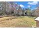 A partially shaded backyard with mature trees and partially green grass at 207 Lewey Brook Dr, Cary, NC 27519