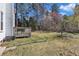 Spacious backyard featuring a deck, lush greenery, and mature trees at 207 Lewey Brook Dr, Cary, NC 27519