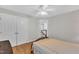 This bedroom boasts wood floors, a ceiling fan, closet, and a view of the staircase at 207 Lewey Brook Dr, Cary, NC 27519