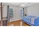 This bedroom features two windows, wood floors, and a blue and white bedspread at 207 Lewey Brook Dr, Cary, NC 27519