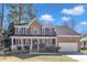 Charming brick two-story home featuring a welcoming front porch and attached two-car garage at 207 Lewey Brook Dr, Cary, NC 27519