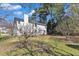 Back exterior of the home showing mature trees and partial view of the lot at 207 Lewey Brook Dr, Cary, NC 27519