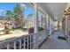 Inviting front porch features white railings, columns, and lush landscaping with flowering bushes at 207 Lewey Brook Dr, Cary, NC 27519