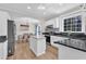 Modern kitchen open to dining area with granite counters, stainless appliances, and bright, natural light at 207 Lewey Brook Dr, Cary, NC 27519