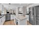 Kitchen with stainless steel appliances, white cabinetry, light countertops, and large island at 207 Lewey Brook Dr, Cary, NC 27519