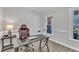 Well-lit home office with a sleek black desk, ergonomic chair, and large windows at 207 Lewey Brook Dr, Cary, NC 27519