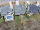 Aerial view of a house with a pool, patio, outdoor furniture, trampoline, and manicured backyard bordering a wooded area at 2073 Amalfi Pl, Apex, NC 27502