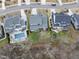 An aerial view of a house featuring a backyard pool, patio seating and established landscaping bordering a wooded area at 2073 Amalfi Pl, Apex, NC 27502