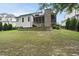 Expansive backyard featuring a stone retaining wall, lush grass, and a screened-in porch at 2073 Amalfi Pl, Apex, NC 27502