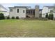 Large backyard with a retaining wall, green lawn, and a view of the screened porch at 2073 Amalfi Pl, Apex, NC 27502