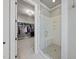 Bright bathroom featuring glass enclosed shower, bench and walk-in closet at 2073 Amalfi Pl, Apex, NC 27502
