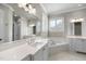 Bright bathroom featuring dual sinks, soaking tub and large mirror at 2073 Amalfi Pl, Apex, NC 27502