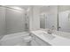 Bright bathroom featuring shower-tub combo, gray tile surround and marble countertop at 2073 Amalfi Pl, Apex, NC 27502