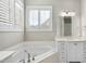 Bright bathroom featuring soaking tub, plantation shutters and sink at 2073 Amalfi Pl, Apex, NC 27502
