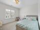 Bright bedroom featuring a large window, a bed with pastel bedding, and a charming chair at 2073 Amalfi Pl, Apex, NC 27502