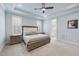 Well-lit main bedroom with tray ceiling, neutral carpet, and access to ensuite bathroom at 2073 Amalfi Pl, Apex, NC 27502