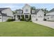 Elegant home with a manicured lawn, featuring a covered front porch and three-car garage at 2073 Amalfi Pl, Apex, NC 27502