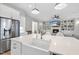 Kitchen island with seating and stainless steel refrigerator with views of the living room at 2073 Amalfi Pl, Apex, NC 27502