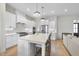 Modern kitchen features stainless steel appliances, island with seating, and wood floors at 2073 Amalfi Pl, Apex, NC 27502