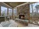 This covered back porch features a stone fireplace with seating and a view to the back yard at 2073 Amalfi Pl, Apex, NC 27502