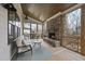 Relaxing screened-in porch featuring a stone fireplace, comfortable seating, and a ceiling fan for year-round enjoyment at 2073 Amalfi Pl, Apex, NC 27502