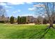 Expansive backyard with lush green grass and mature landscaping to include several rows of evergreen trees at 212 Whirlaway Ln, Chapel Hill, NC 27516