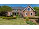 Stately brick home with lush landscaping, trimmed hedges and manicured lawn at 212 Whirlaway Ln, Chapel Hill, NC 27516