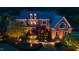 Beautiful brick home with manicured landscaping and warm exterior lighting at dusk at 212 Whirlaway Ln, Chapel Hill, NC 27516