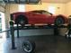 Car on lift in garage featuring tire and accessories at 212 Whirlaway Ln, Chapel Hill, NC 27516