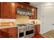 Close-up of gourmet kitchen featuring stainless steel stove, custom cabinets, and granite countertops at 212 Whirlaway Ln, Chapel Hill, NC 27516