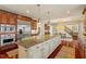 Gourmet kitchen featuring custom cabinets, stainless steel appliances, large center island, and stone countertops at 212 Whirlaway Ln, Chapel Hill, NC 27516