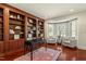 Traditional home office featuring wood bookshelves, hardwood flooring, and bright window seating at 212 Whirlaway Ln, Chapel Hill, NC 27516