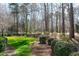 Mature landscaping with flowering bushes defines the perimeter of the lush green backyard at 218 Whisperwood Dr, Cary, NC 27518