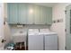 Efficient laundry room has a sink, washer, dryer, and convenient upper storage cabinets at 218 Whisperwood Dr, Cary, NC 27518