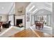 Open-concept living room with a fireplace, hardwood floors, and bright windows overlooking the backyard at 218 Whisperwood Dr, Cary, NC 27518