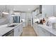 Bright kitchen with stainless appliances, white cabinets, an island with a sink, and hardwood flooring at 230 Tidal Pool Way, Cary, NC 27519