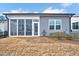Back of home featuring a screened-in porch, gray siding, manicured landscaping, and blue skies at 244 Mahogany Run, Raleigh, NC 27610