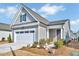 Charming single-story home featuring a two-car garage, gray siding, and manicured landscaping at 244 Mahogany Run, Raleigh, NC 27610