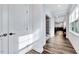 Bright hallway with wood-look flooring and white trim, leading to a well-lit living space at 244 Mahogany Run, Raleigh, NC 27610