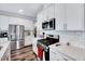 Well-equipped kitchen featuring stainless steel appliances and sleek white cabinetry and backsplash at 244 Mahogany Run, Raleigh, NC 27610