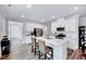 Open-concept kitchen with white cabinetry, a central island, stainless steel appliances, and wood-look floors at 244 Mahogany Run, Raleigh, NC 27610