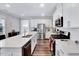 Bright kitchen featuring white cabinets, stainless steel appliances, a central island, and wood-look flooring at 244 Mahogany Run, Raleigh, NC 27610